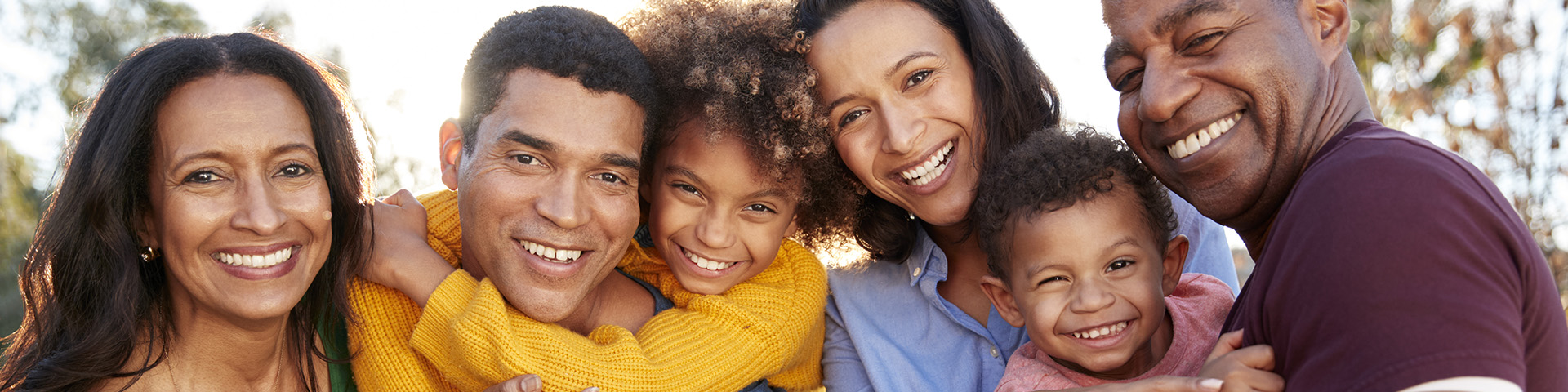 group of family members of various ages smiling next to each other